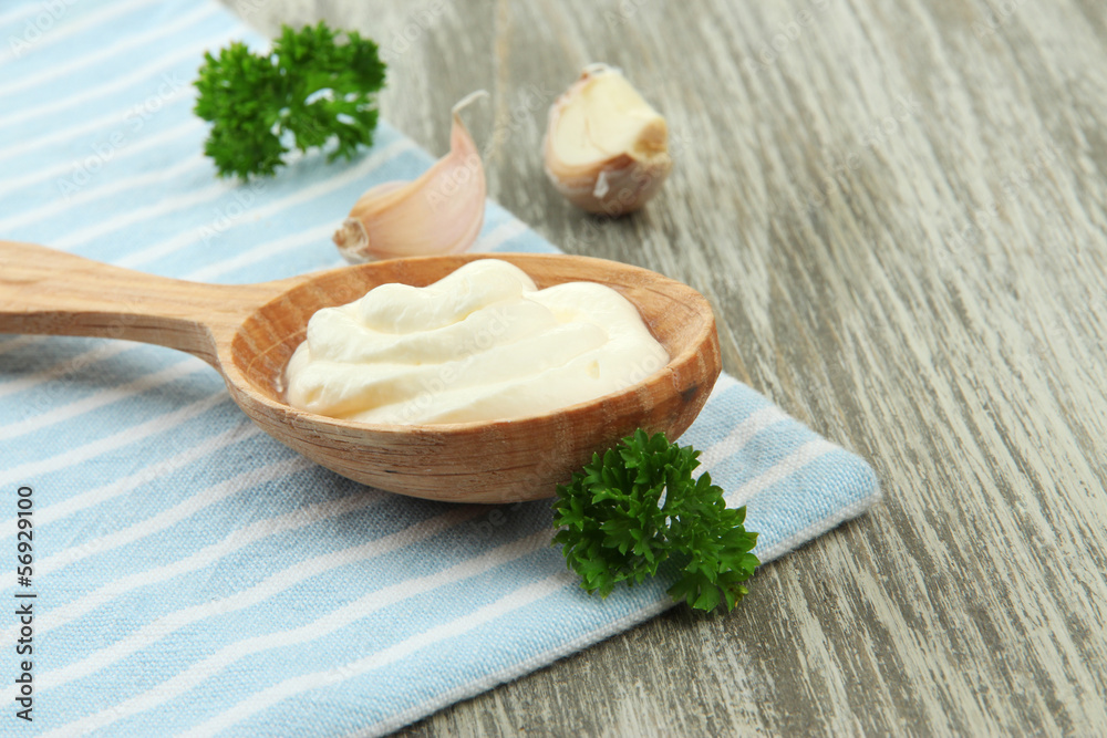 Sour cream in spoon on table close-up Sour cream in spoon on table close-up