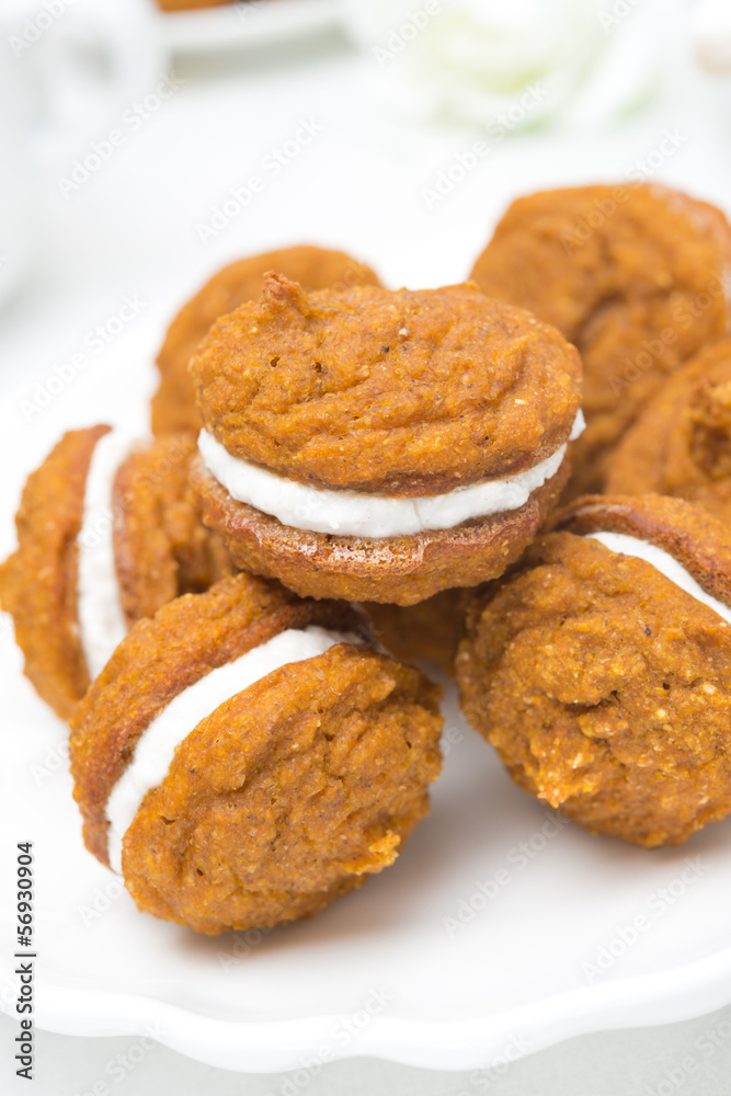 Pumpkin cookies with cream filling on the plate, close-up Pumpkin cookies with cream filling on the plate, close-up