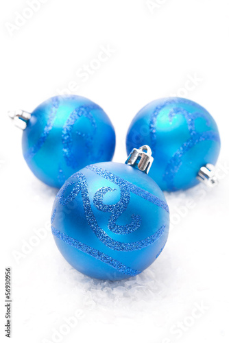 three blue Christmas balls on snow isolated