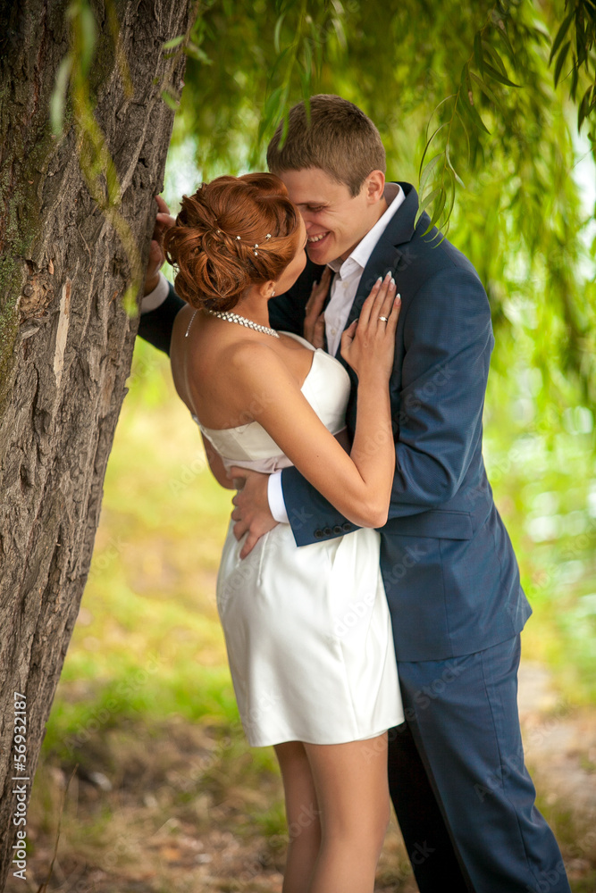 Handsome man snuggling woman to tree Handsome man snuggling woman to tree