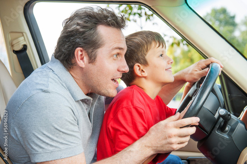 Father gives his son driver lessons, enjoying time together © BlueSkyImages