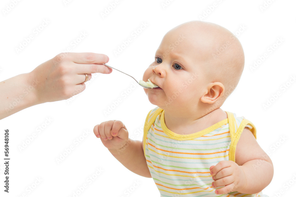 Mother's hand feeding baby with a spoon Mother's hand feeding baby with a spoon