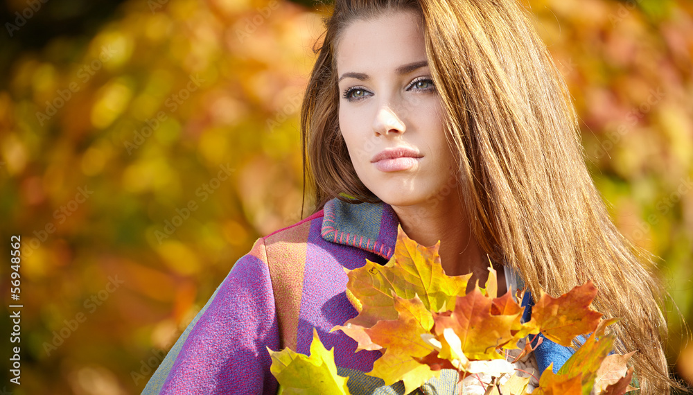 Young woman with autumn leaves in hand and fall yellow maple gar Young woman with autumn leaves in hand and fall yellow maple gar