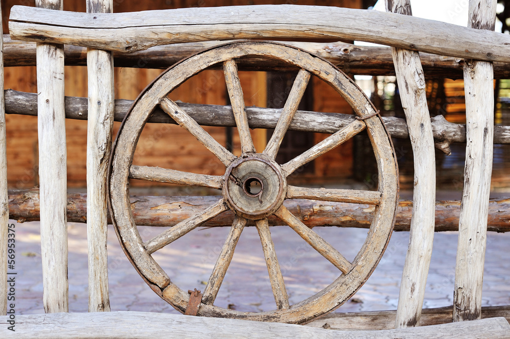 old wood coach wheel around barn