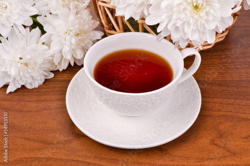 A mug of tea and white chrysanthemums