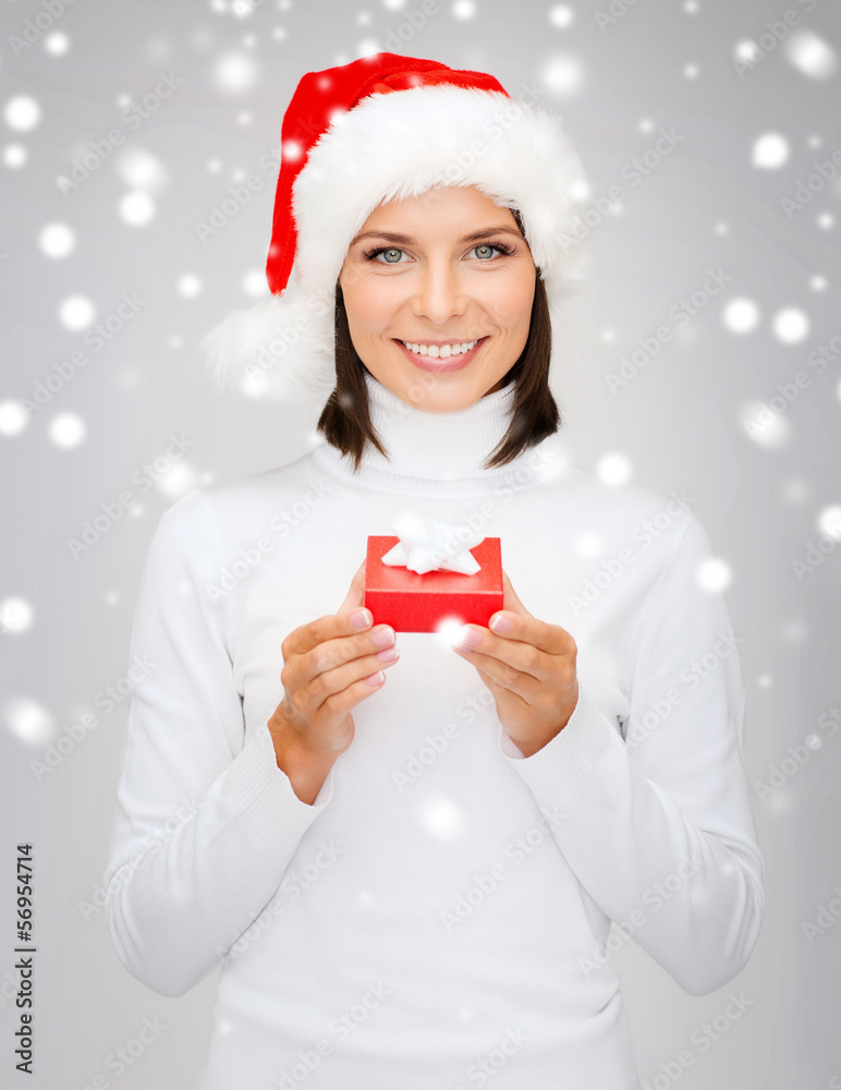 smiling woman in santa hat with small gift box smiling woman in santa hat with small gift box