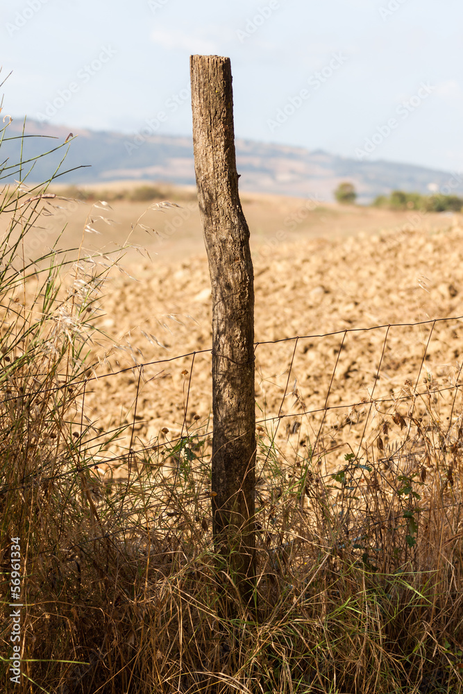 a fence post and an italian farm field