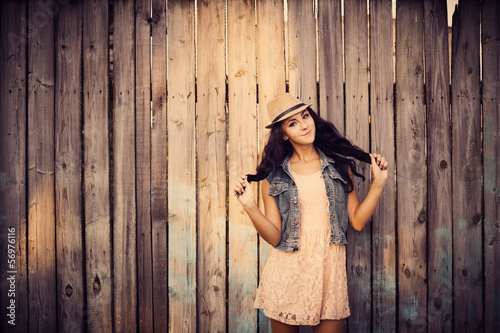 young beautiful girl on background wooden wall
