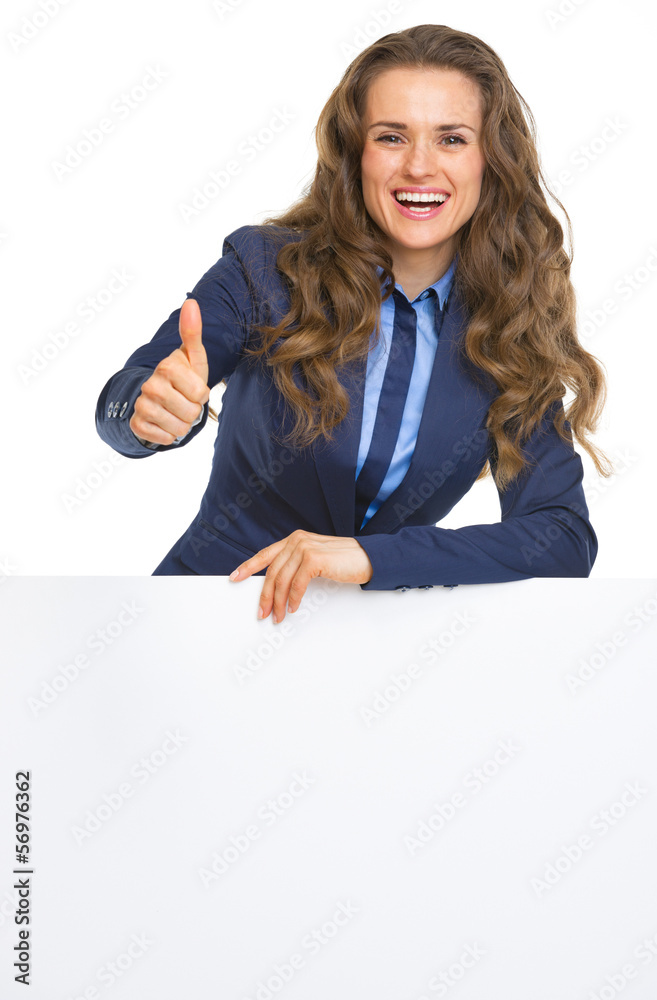 Smiling business woman showing blank billboard and thumbs up Smiling business woman showing blank billboard and thumbs up