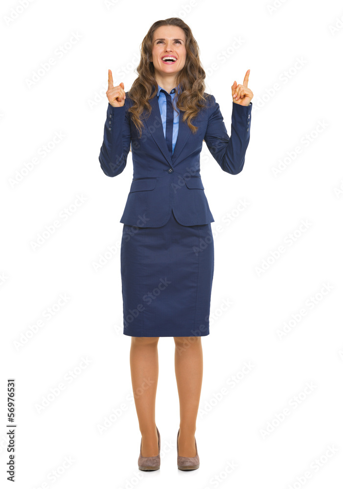 Full length portrait of smiling business woman pointing up Full length portrait of smiling business woman pointing up