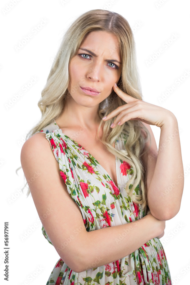 Frowning pretty blonde wearing flowered dress posing Frowning pretty blonde wearing flowered dress posing