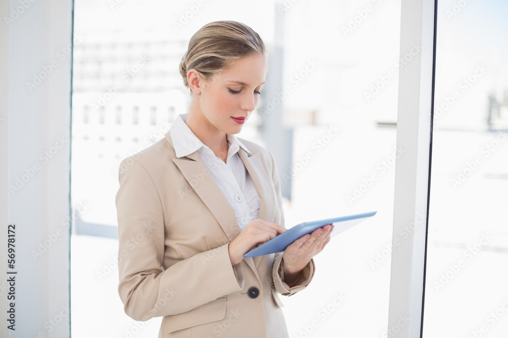 Focused blonde businesswoman using tablet pc Focused blonde businesswoman using tablet pc