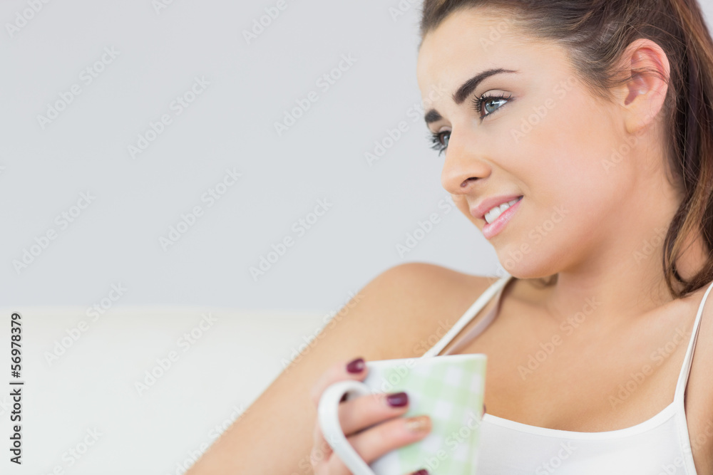 Thoughtful young woman holding a cup Thoughtful young woman holding a cup