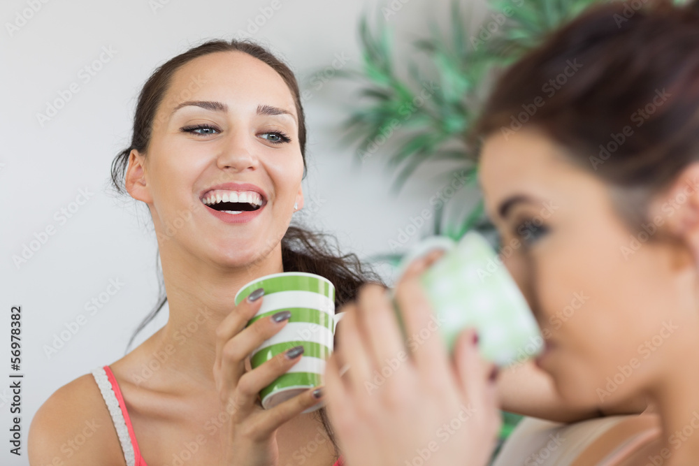 Young laughing woman having coffee with friend Young laughing woman having coffee with friend