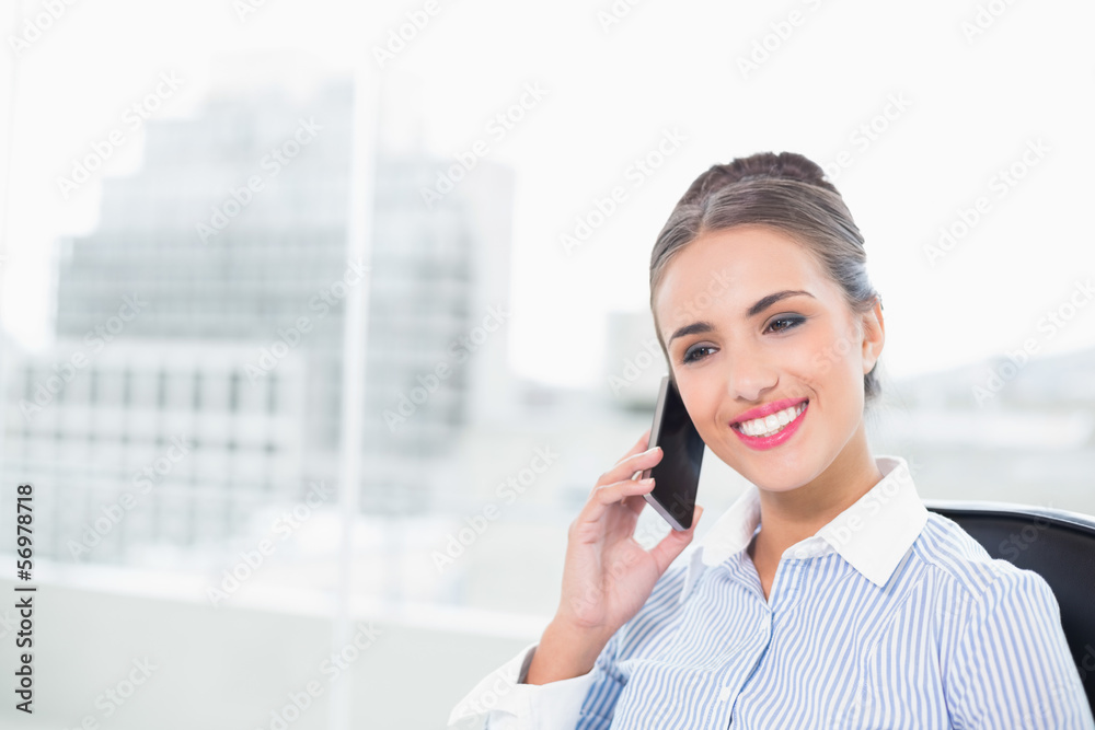 Laughing brunette businesswoman phoning with smartphone