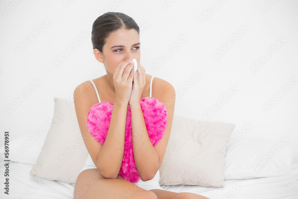 Depressed young brown haired model in white pajamas crying in a Depressed young brown haired model in white pajamas crying in a