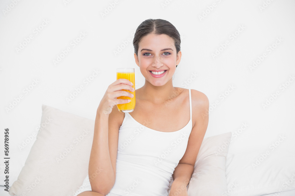 Dynamic young brown haired model in white pajamas holding a glas Dynamic young brown haired model in white pajamas holding a glas