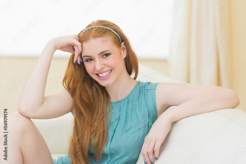 Happy redhead sitting on the couch smiling at camera Happy redhead sitting on the couch smiling at camera
