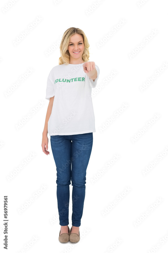Fototapeta premium Smiling blonde volunteer pointing at camera