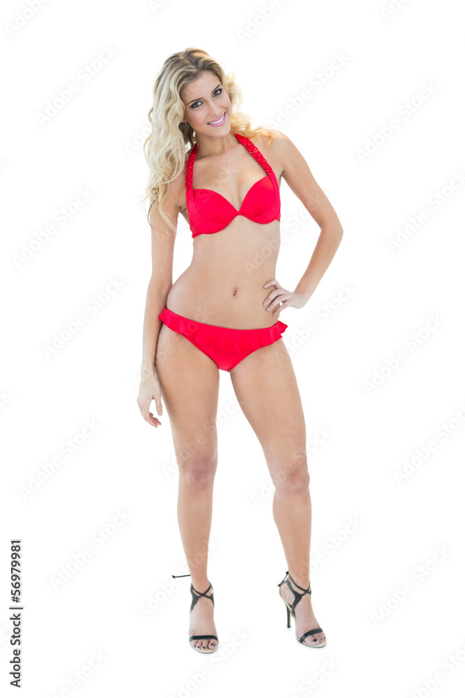 Cheerful pretty blonde model posing with hand on hips wearing re Cheerful pretty blonde model posing with hand on hips wearing re