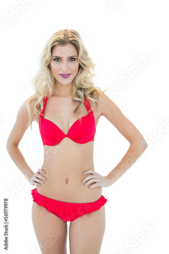 Attractive blonde model posing with hands on hips wearing bikini