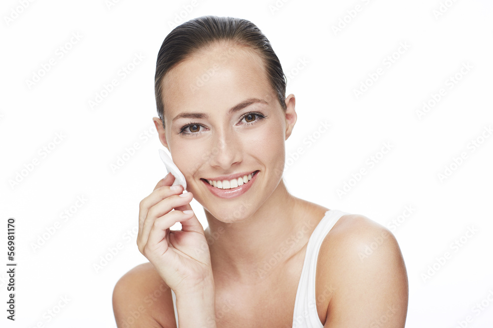 Portrait of young woman using cotton pad Portrait of young woman using cotton pad