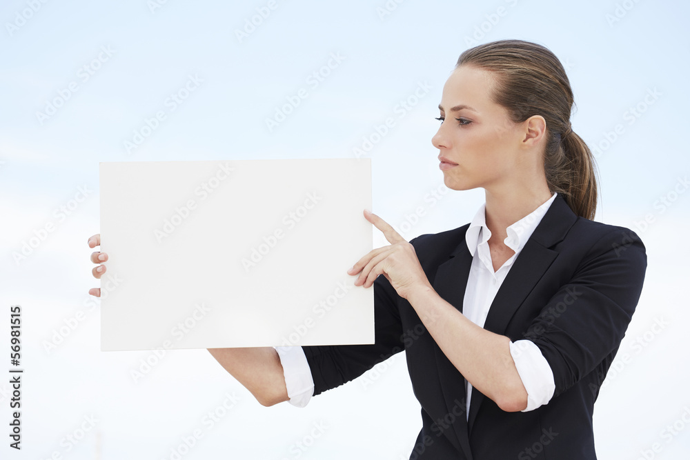 Young businesswoman looking at blank sign Young businesswoman looking at blank sign