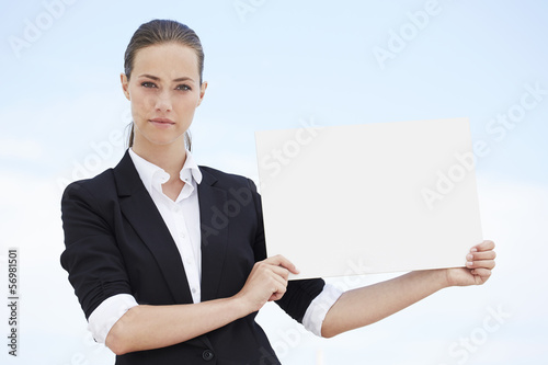 Fotografija Portrait of young businesswoman holding blank sign
