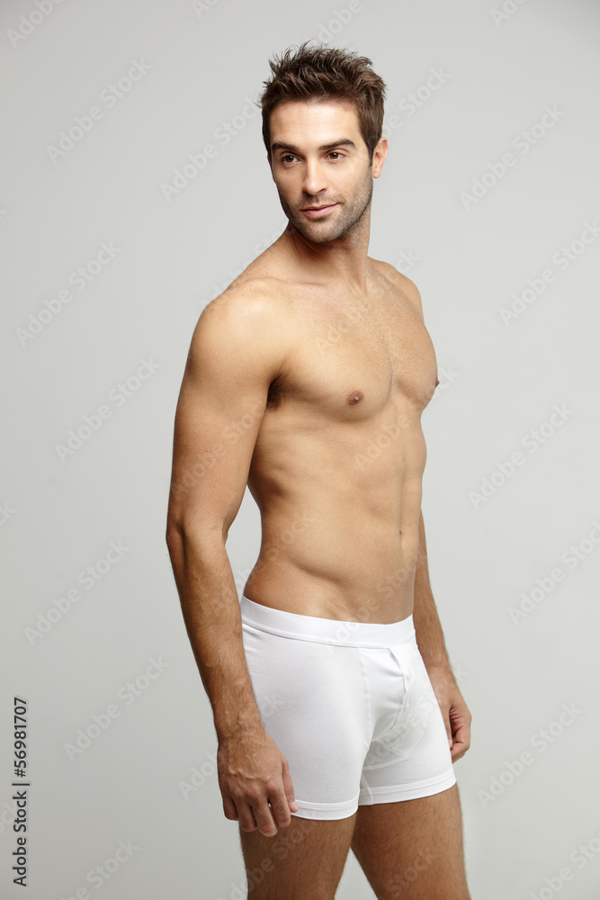 Mid adult man in underpants looking away, studio shot