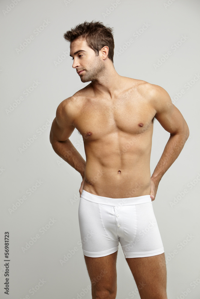 Mid adult man in underpants looking away, studio shotv