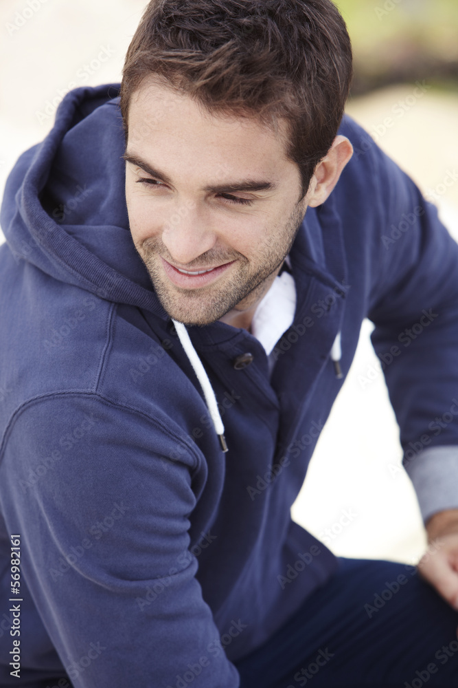 Mid adult man in hooded top outdoors, smiling Mid adult man in hooded top outdoors, smiling