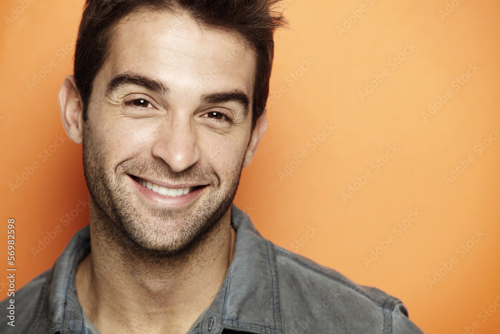 Portrait of mid adult man smiling against orange background Portrait of mid adult man smiling against orange background