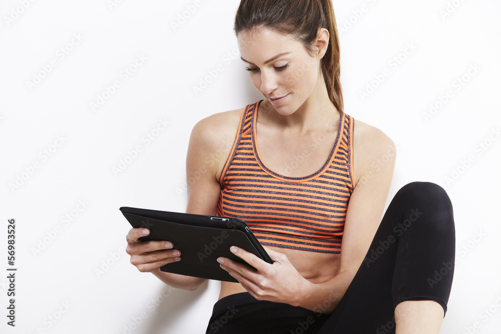 Young attractive woman using a digital tablet after workout Young attractive woman using a digital tablet after workout