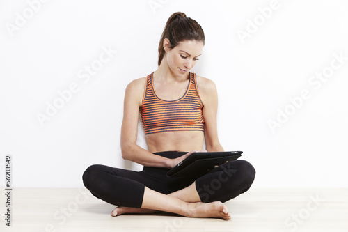 Young attractive woman using a digital tablet after workout