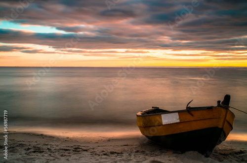 Old boat at beach during sunset