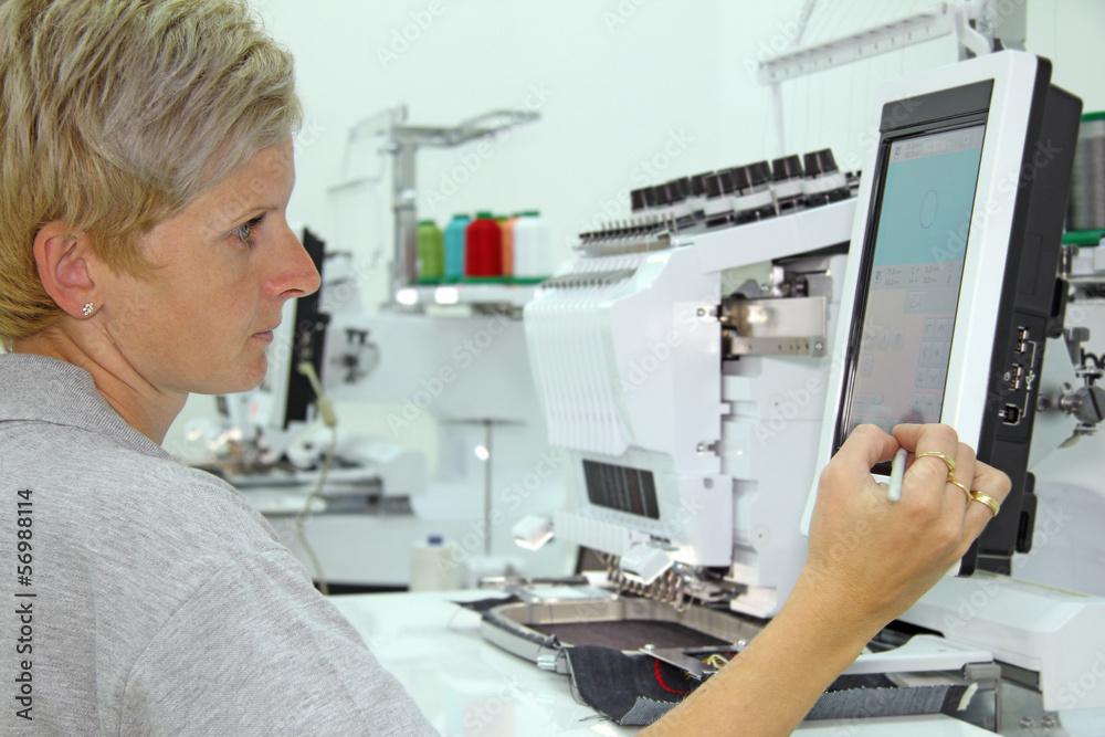 Woman working on computerized machine embroidery Woman working on computerized machine embroidery