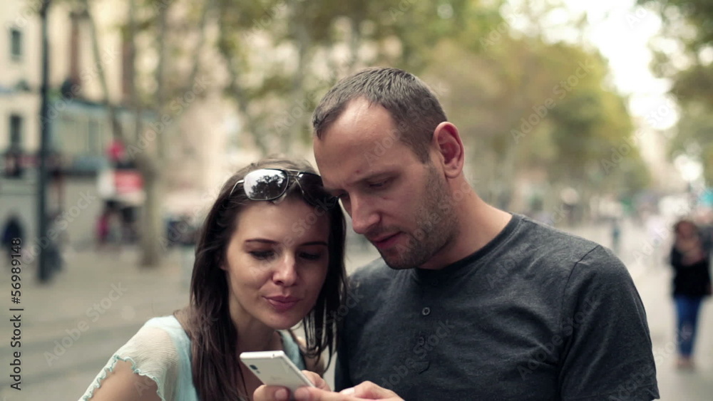 Young couple taking photo with cellphone in the city Young couple taking photo with cellphone in the city