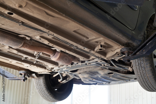 car lifted on auto hoist at service station