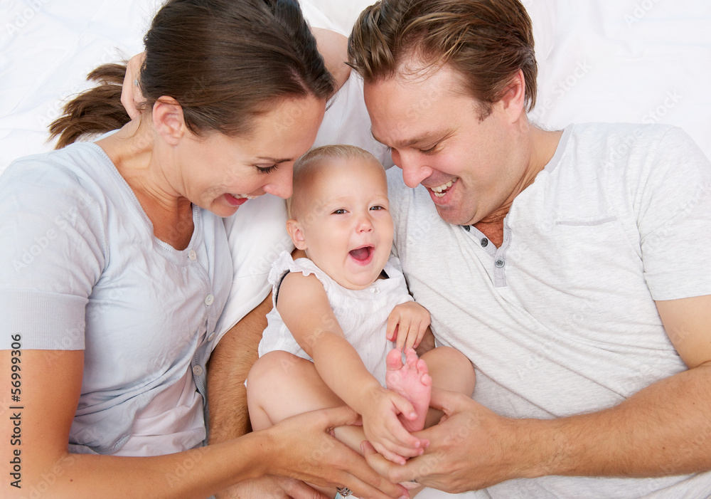 Portrait of a happy mother and father playing with cute baby Portrait of a happy mother and father playing with cute baby