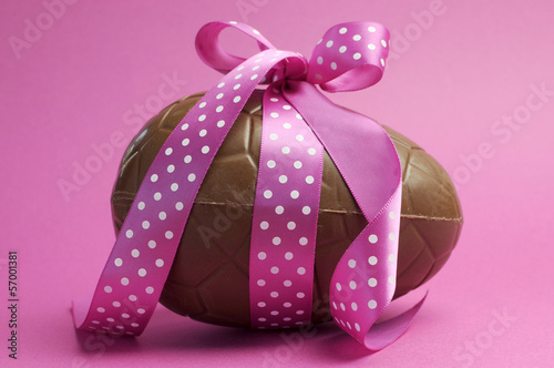 Beautiful pink polka dot ribbon around chocolate Easter egg