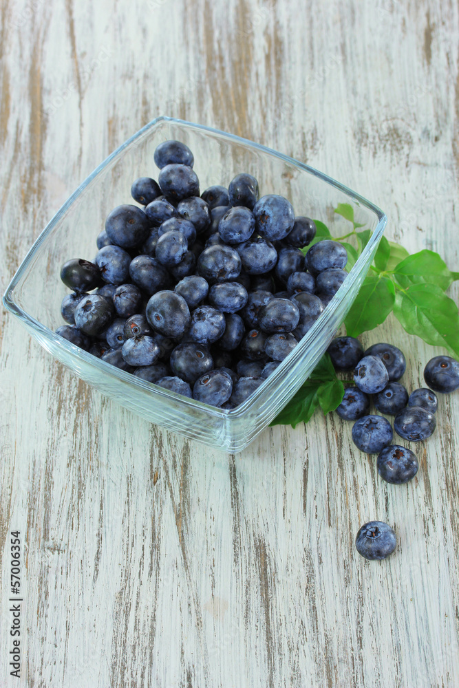 Blueberries in glass bowl on wooden table Blueberries in glass bowl on wooden table