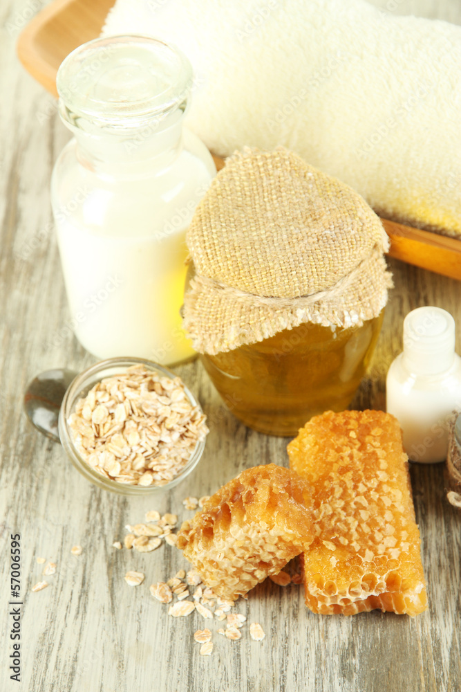 Honey and milk spa with oils and honey on wooden table close-up Honey and milk spa with oils and honey on wooden table close-up