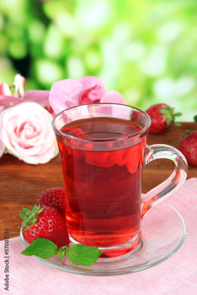 Delicious strawberry tea on table on bright background Delicious strawberry tea on table on bright background