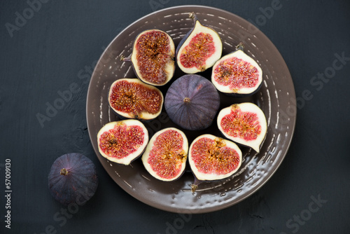Ceramic plate with ripe sliced figs, view from above