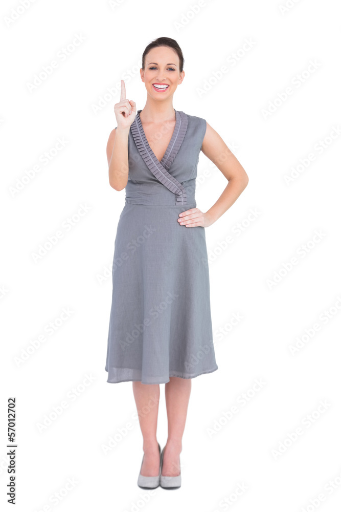 Cheerful elegant woman in classy dress pointing her finger up Cheerful elegant woman in classy dress pointing her finger up