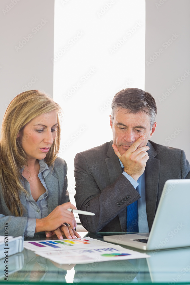 Two thoughtful businesspeople trying to understand figures Two thoughtful businesspeople trying to understand figures