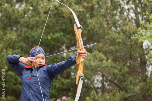 Concentrating brunette practicing archery