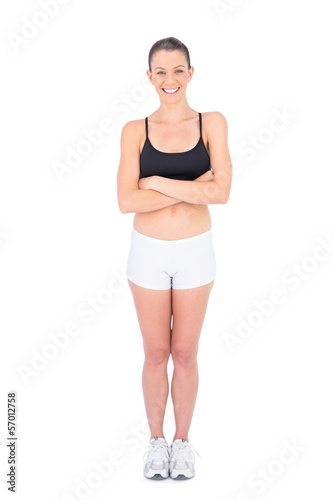 Smiling woman in sportswear crossing arms looking at camera