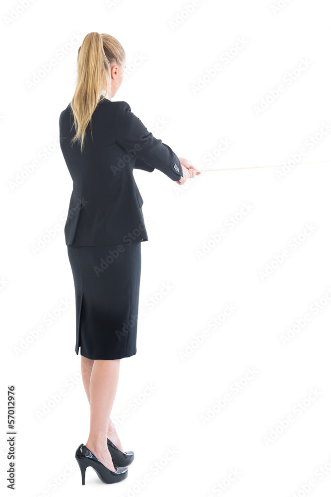 Rear view of standing business woman pulling a rope Rear view of standing business woman pulling a rope