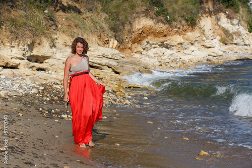 woman in a red dress on the ocean coast.Freedom Concept.